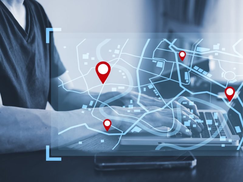 Man using laptop with virtual world and model map with location point , GPS app, icon Travel maps and find places in the online system, all screen graphics are generated,Searching for travel.