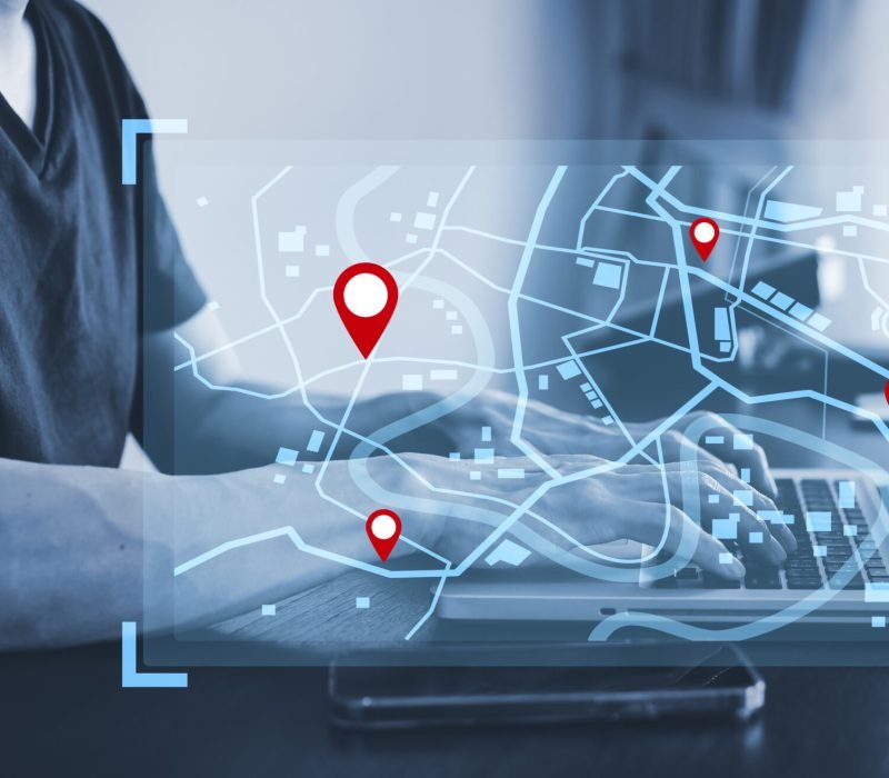 Man using laptop with virtual world and model map with location point , GPS app, icon Travel maps and find places in the online system, all screen graphics are generated,Searching for travel.